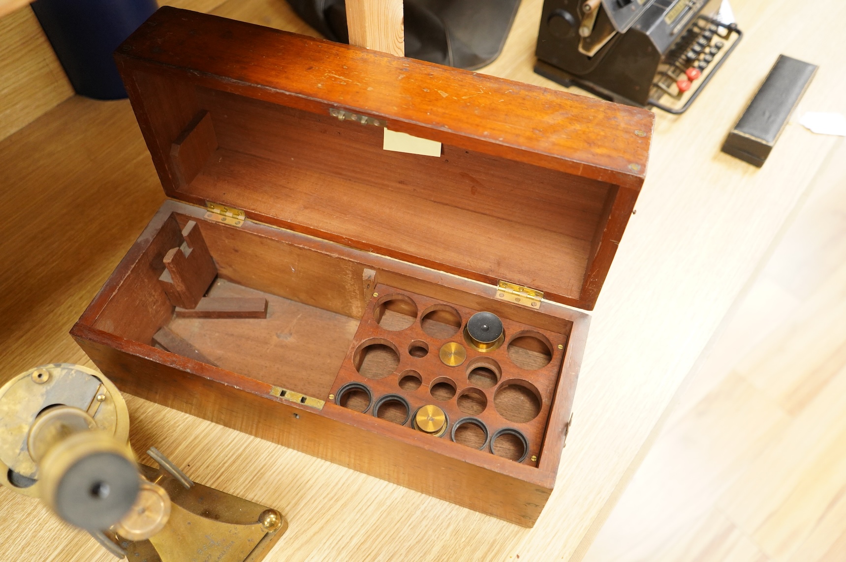 A late 19th century brass compound monocular microscope, by R and J. Beck, mahogany cased, with two objectives, 2 eyepieces and miscellaneous slides, the case dimensions; 40.5 x 15.5x 18cm, together with a small early 19